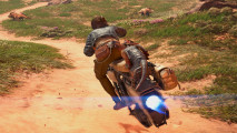 Star Wars Outlaws preview: A woman wearing a blue jacket and brown pants sits on a motorbike with a small, reptilian alien riding along on the back, scooting along a brown dirt path in a wasteland area